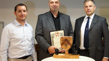Luke Palmer, Designer at Orangebox (left), presenting the 2013 Furniture Makers’ Sustainability Award to Paul Hobson, Marketing Director at Senator (center), and Jonny Westbrooke, Chief Executive and 